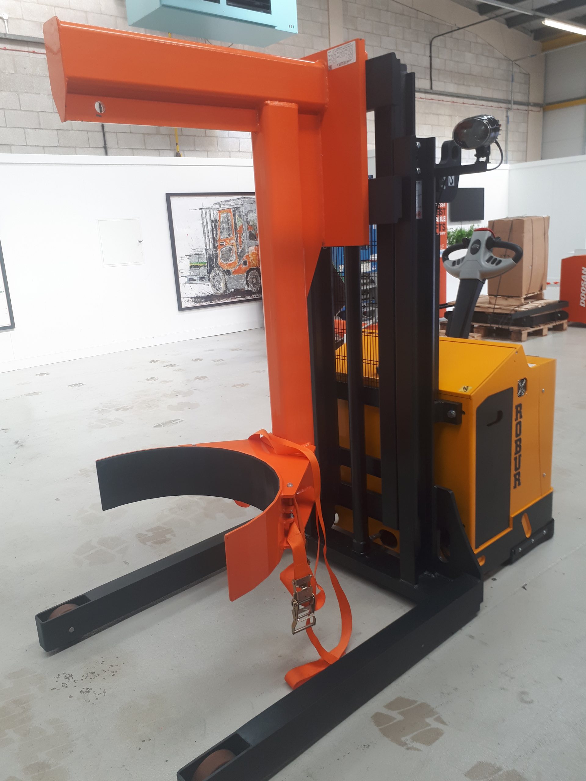 SBM XT 30, 3000kg pedestrian straddle stacker, chainless lift/lower with customers own design of barrel clamp for the movement of stainless-steel drum stillages for the nuclear industry.